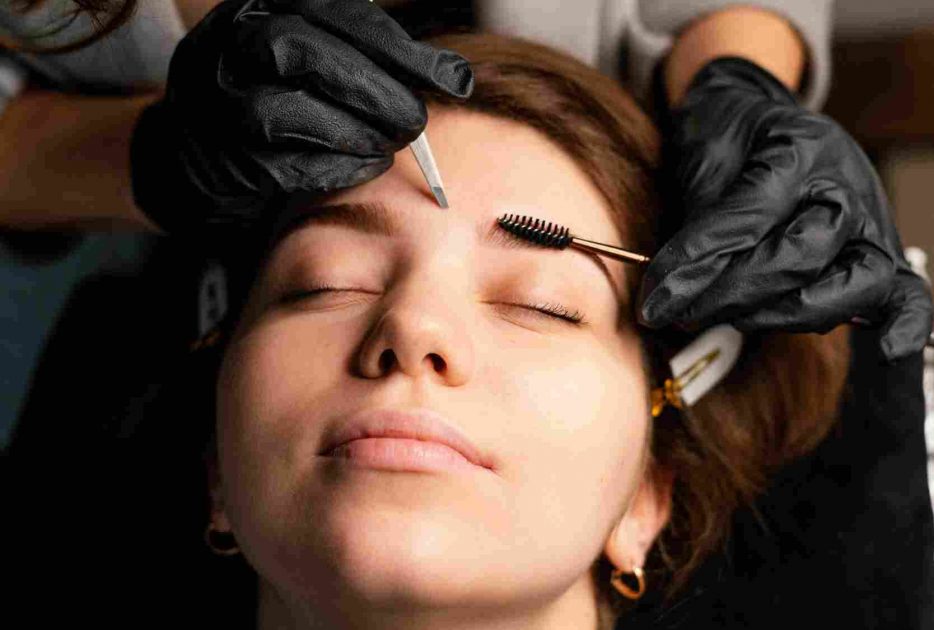 high-angle-female-clinician-doing-eyebrow-treatment-woman_11zon